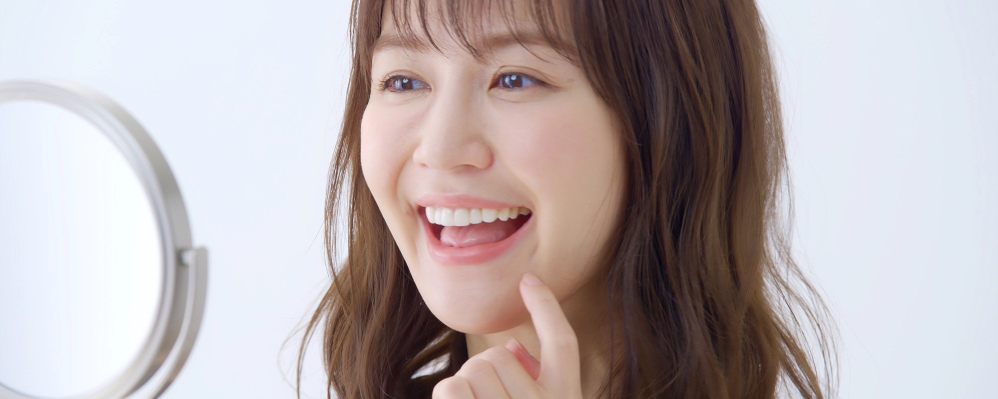 鏡を見ながら口元を確認する女性